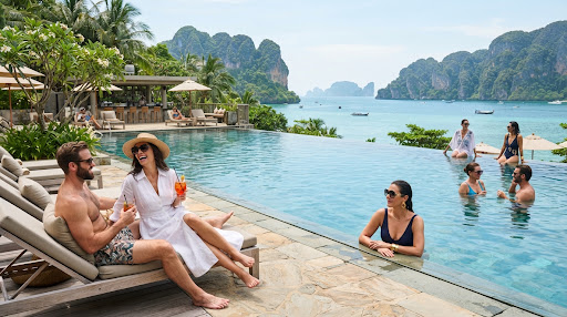 Luxury resort infinity pool above turquoise water and green cliffs